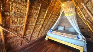 a room with a bed in a straw hut at Paradise Beach Bacalar A Pie De Laguna in Bacalar