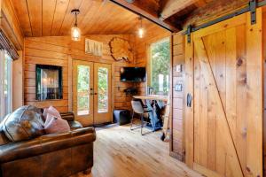 a living room with a leather couch in a wooden cabin at Owl's Perch Treehouse in Sooke