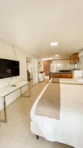 a large bedroom with two beds and a desk at Hotel Velejar in Cumbuco