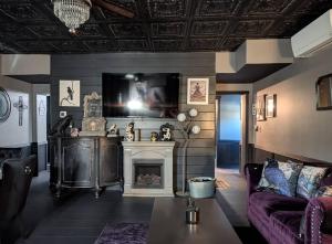 a living room with a fireplace and a purple couch at The Raven in Madison