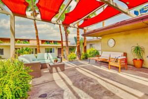 an outdoor patio with red umbrellas and furniture at Lido Palms Resort and Spa in Desert Hot Springs +25 photos