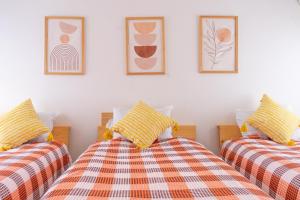 two twin beds in a room with pictures on the wall at Lino下伊福 in Okayama