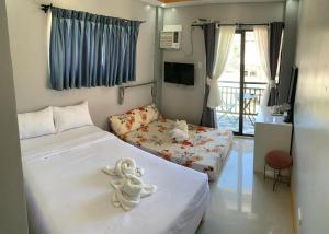 a room with two beds with a teddy bear on it at ANDABAY Tourist Inn in Anda