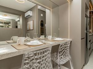 a kitchen with a counter with chairs and a refrigerator at Studio 208 Premium 450m do Consulado EUA in Porto Alegre