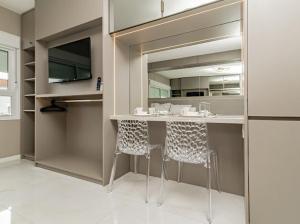 a kitchen with a counter with two stools in it at Studio 208 Premium 450m do Consulado EUA in Porto Alegre