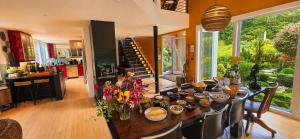 a kitchen with a table with flowers on it at Modern Glass House with Firepit, Views & Private Retreat in Elka Park