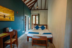 a bedroom with a bed with blue walls and a table at Ecoya Riverside Resort in Balapitiya +88 photos