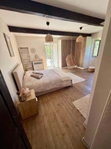 a bedroom with a bed and a wooden floor at La Grange de Bosc -Ardèche verte - Proche train de Lamastre in Saint-Prix +101 photos