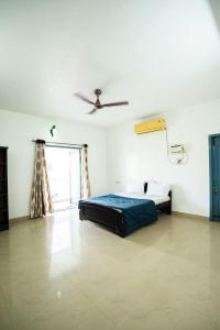 a bedroom with a bed and a ceiling fan at Classic Horizon in Mahabalipuram +11 photos