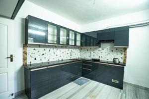 a kitchen with black cabinets and a wooden floor at Classic Horizon in Mahabalipuram
