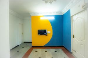 a room with a colorful wall with a tv on it at Classic Horizon in Mahabalipuram