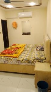 a bed in a room with a yellow blanket on it at Hotel Seven View Lahore in Lahore