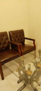 a brown couch and a glass table in a room at Hotel Seven View Lahore in Lahore +2 photos