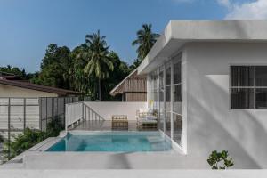 a white house with a swimming pool in the backyard at Blue Garden Villa A in Ban Madua Wan