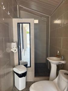 a bathroom with a sink and a toilet and a mirror at Conchal Maquito House in Brasilito +31 photos