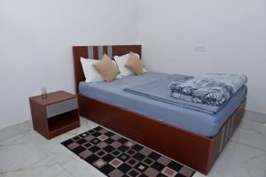 a bedroom with a bed with blue sheets and a table at Trance Himalaya in Gupta Kāshi
