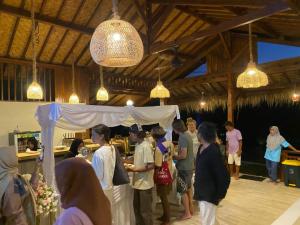a group of people standing under a tent at Saluvi Hill's in Pulau Sarang