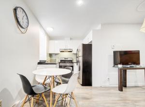 eine Küche mit Tisch und Stühlen und einer Uhr an der Wand in der Unterkunft Griffintown Hideout in Montreal