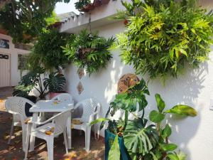 a table and chairs next to a wall with plants at Hotel OK El Edén in Tocaima