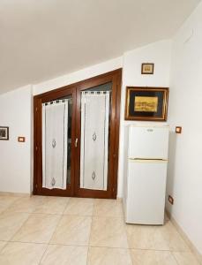 a kitchen with a door and a refrigerator in a room at domus rosada in Ripa Teatina