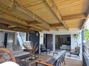 a living room with a wooden ceiling and a patio at Villa Chelsy in Capesterre-Belle-Eau