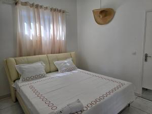 a bed sitting in a room with a window at Villa Chelsy in Capesterre-Belle-Eau