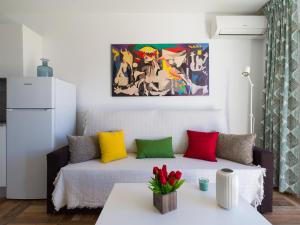 a living room with a couch with colorful pillows at Incredible Sunsets in Puerto Rico de Gran Canaria +102 photos