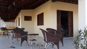 a group of chairs and tables on a patio at Casa de praia Morro Branco in Beberibe