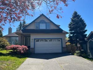 a house with a garage and a tree at Cheng Rental in Surrey