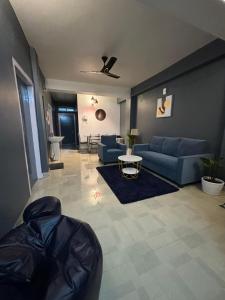 a living room with blue couches and a table at Serene Cove Homestay in Dispur +9 photos
