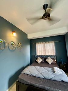 a bedroom with a bed with blue walls and a ceiling at Serene Cove Homestay in Dispur