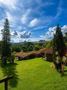 a grassy yard with two buildings in the background at Sopro do Vento Roots Hotel in Analândia