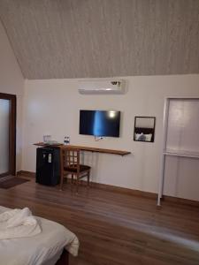 a room with a bed and a tv on a wall at Sea Shades Cottages with Private Jacuzzi in Palolem