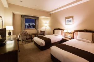 HOTEL MYSTAYS Sapporo Aspen في سابورو: غرفة فندقية بسريرين ونافذة