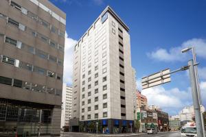 a tall white building on a city street at HOTEL MYSTAYS Sapporo Station in Sapporo