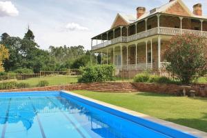 an old house with a swimming pool in front of it at Bungaree Station in Clare