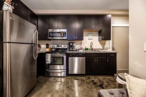 a kitchen with stainless steel appliances and black cabinets at The West End Flats Hotel in Roanoke