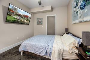 a bedroom with a bed and a tv on the wall at The West End Flats Hotel in Roanoke
