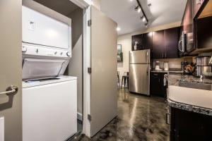 a small kitchen with a refrigerator and a sink at The West End Flats Hotel in Roanoke