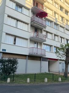 ein Wohnhaus mit einem roten Sonnenschirm auf den Balkonen in der Unterkunft Yara in Montargis