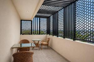 ein Balkon mit Tisch und Stühlen und einem Fenster in der Unterkunft DeVerveil Service Apartment in Mysore
