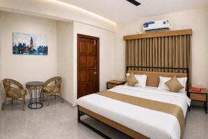 ein Schlafzimmer mit einem Bett, einem Tisch und Stühlen in der Unterkunft DeVerveil Service Apartment in Mysore