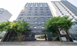 a tall building with a doorway in front of it at Nabeeya Hotel in Siheung