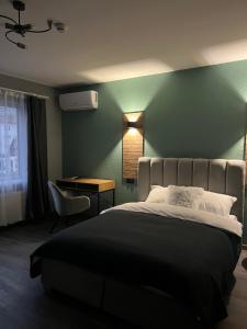 a bedroom with a large bed with a green wall at Hotel Menchul in Rakhiv