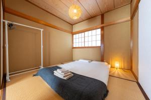 a bedroom with a bed with towels on it at Coto House Kamakura RoomB in Kamakura