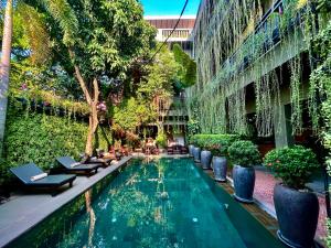a swimming pool in the middle of a building with plants at Won Residence & Spa in Siem Reap