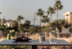 a plate of food and glasses of water on a table at AKU Suites with private pools in Stalís
