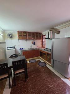 a kitchen with a refrigerator and a table and chairs at Toul Sleng Double Room in Phnom Penh