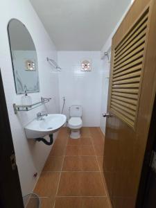 a bathroom with a sink and a toilet and a mirror at Toul Sleng Double Room in Phnom Penh