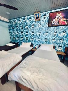 two beds in a room with a blue wall at Hotel MK in Ratlām +20 photos